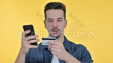 年轻人在智能手机上<strong>在线支付</strong>的肖像，黄色背景